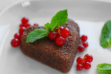 Delicious fondant with red currant on plate, closeup