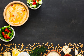 Hummus on a black wooden background