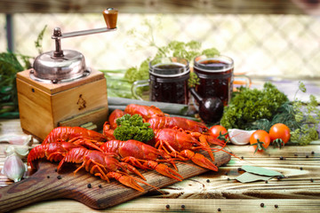 Boiled red crayfishes with a beer on a wooden table.