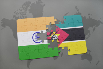 puzzle with the national flag of india and mozambique on a world map background.