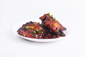 Grilled chicken or ayam golek on white plate, white background.