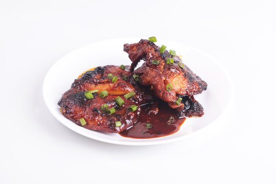Grilled chicken or ayam golek on white plate, white background.