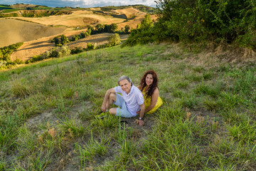 mature couple sitting in grassy field