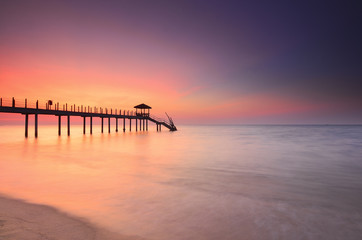 Fototapeta na wymiar Long exposure of long fisherman jetty during sunset.