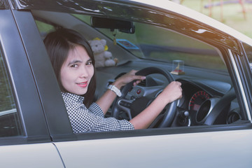 a beautiful young woman driving cars white
