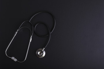 Stethoscope on black background with space for text - health concept
