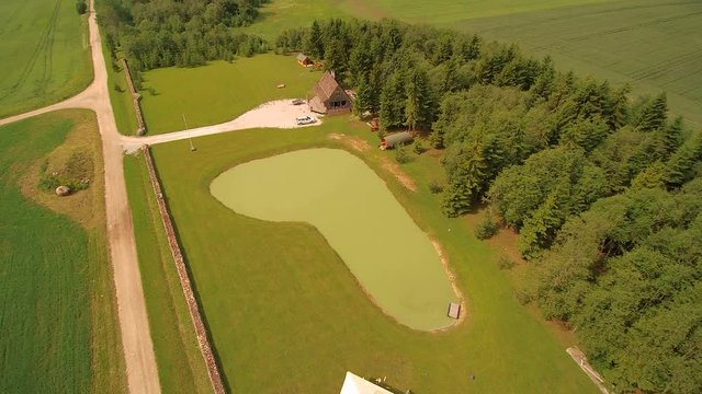 The aerial view of the wooden roof with still uninstalled shingles and the green trees all over