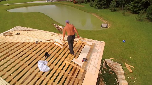 The roofers installing remaining shingles on the wooden roof
