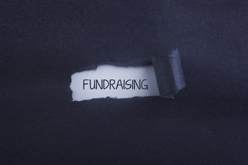 fundraising word under torn black sugar paper