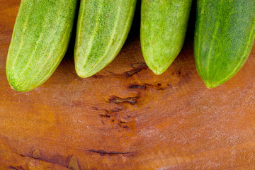 fresh green cucumbers on wooden background healthy raw vegetable food isolated
