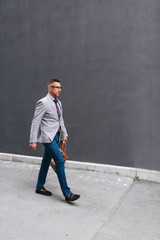 Shot of a stylish mature man crossing a city street. On the way to business meeting