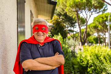 senior dressed as superhero with red cape and mask