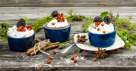 beautiful Christmas cupcake with cream and berry on wooden background cinnamon cones