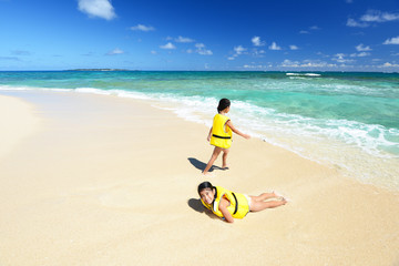 Obraz premium 南国沖縄のビーチで遊ぶ姉妹