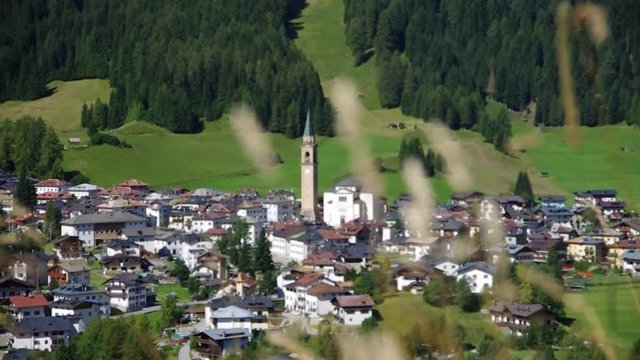 Dolomites, Italy - View of Padola, small town among the Dolomiti Venete. This ski resort will be connected to Sexten - Drei Zinnen in 2017. Rack focus from grass to the church.

