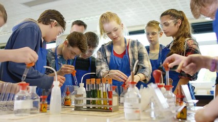  Teacher teaching group of students in school science class - Powered by Adobe