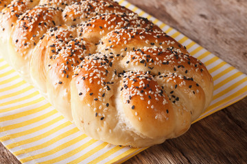 Tasty braided bun with sesame seeds closeup. horizontal
