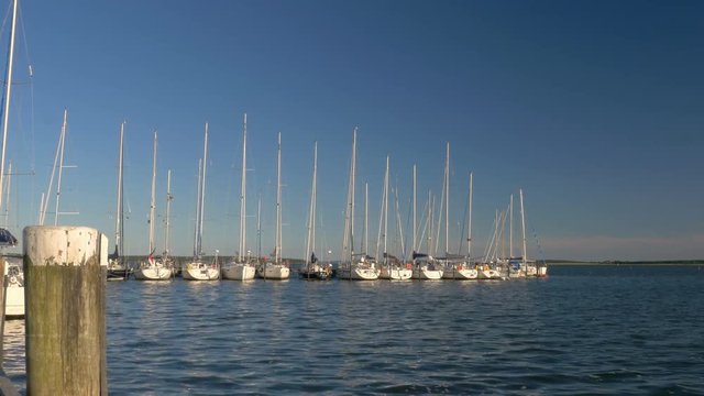 Sailboat harbor sunset - Sailing, sail, ship, boat in marina. Baltic Sea. Clip contains port, harbor, dock, seaport, dawn, sunset	
