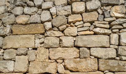 Traditional wall of stones built without lime. Dry stone wall.