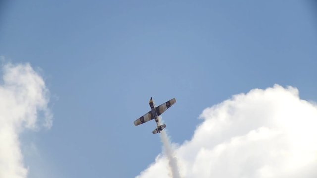 An old historical military soviet russia plane flying and performs aerobatics - vertical barrel roll, slow motion