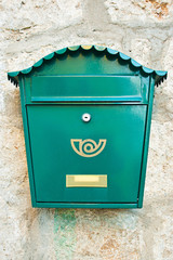 Green mailbox on a wall background