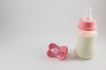 Baby bottle with milk and pacifier on a white background