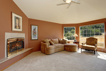 Cozy living room interior with tile fireplace and big windows.