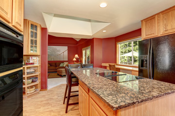 Kitchen room interior with red walls, granite counter top and bar stand.
