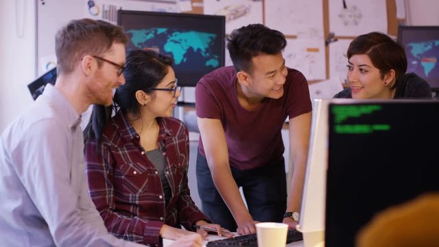  Young computer experts working in office with lots of computers