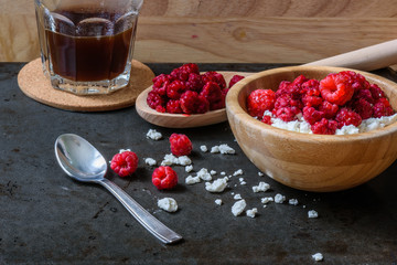 Cottage cheese with raspberries and cup of coffee for breakfast