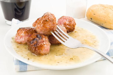 fork picks a meatball cooked in sauce, macro shotting