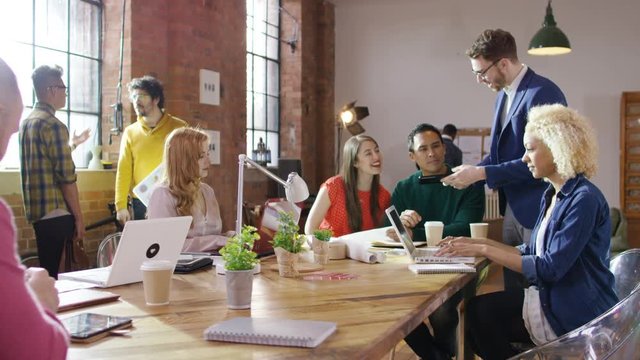  Portrait smiling hipster businessman working with colleagues in loft office