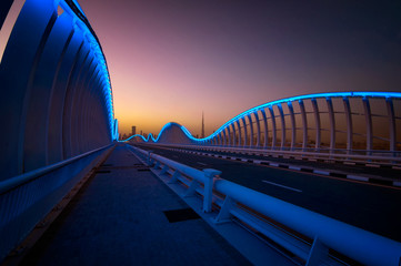 Fototapeta premium Amazing night VIP bridge during beautiful sunset. Private road to Meydan race course, Dubai, United Arab Emirates