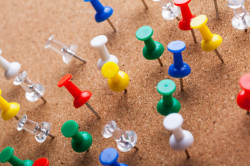Group of thumbtacks pinned on corkboard