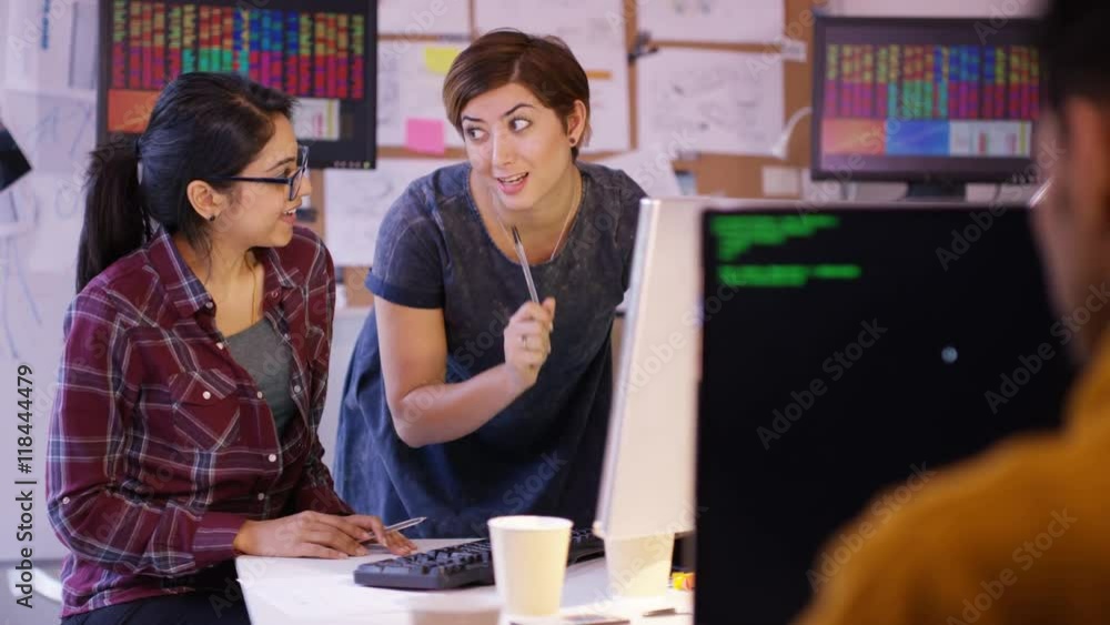 Wall mural young computer experts working in office with lots of computers