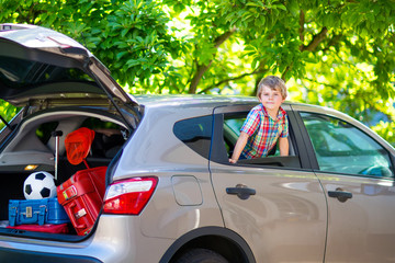 little kid boy sitting in car  just before leaving for vacation