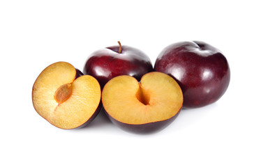 whole and half cut ripe plum on white background