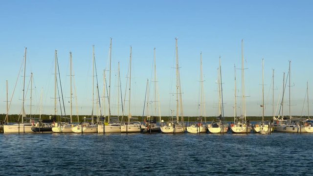 Sailboat harbor sunset - Sailing, sail, ship, boat in marina. Baltic Sea. Clip contains port, harbor, dock, seaport, dawn, sunset	