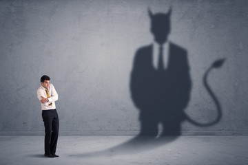 Fototapeta premium Business man looking at his own devil demon shadow concept
