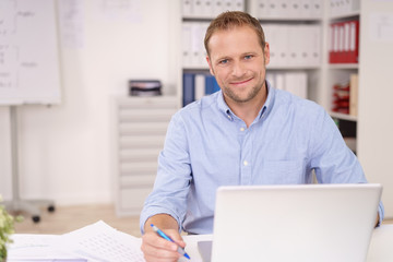 lächelnder mitarbeiter am notebook