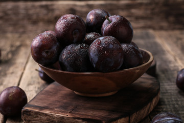 ripe plums on wooden vintage background
