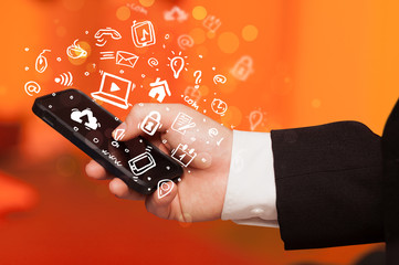 Hand holding smartphone with media icons and symbol