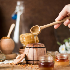 Honey background. Natural honey comb, glass jarand wooden bowls. On wooden rustic table. Soft focus