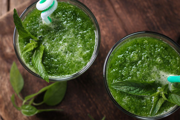 Fresh green smoothie with straws on a wooden table,healthy vegan food