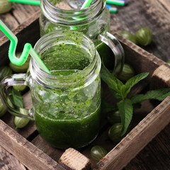 Fresh green smoothie with straws on a wooden table,healthy vegan food