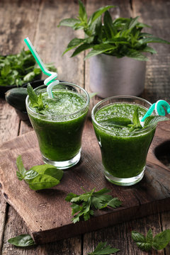 Fresh green smoothie with straws on a wooden table,healthy vegan food