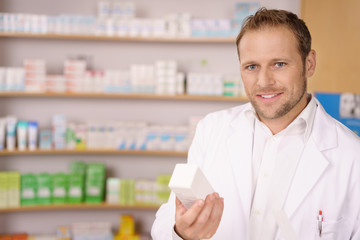freundlicher apotheker hält ein medikament in der hand