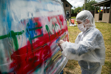 Boy painting retro car in different colors