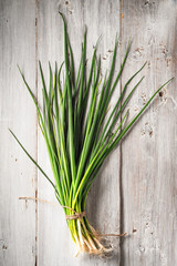 Green onion on the white wooden table vertical