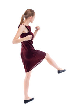 skinny woman funny fights waving his arms and legs. Isolated over white background. A girl in a burgundy dress has foot.